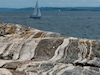 Eine kleine Insel mit Sommerhäusern vor der schwedischen Westküste. Im Kattegatt sind Segler und Küstenmotorschiffe unterwegs. Bei größeren Wellen werden die flachen Rinnen zwischen den Klippen geflutet und das Wasser läuft zwischen den Steinen zurück ins Meer.<br/>Astol, Südschweden, Juli 2010.<br/><br/>01:39 min